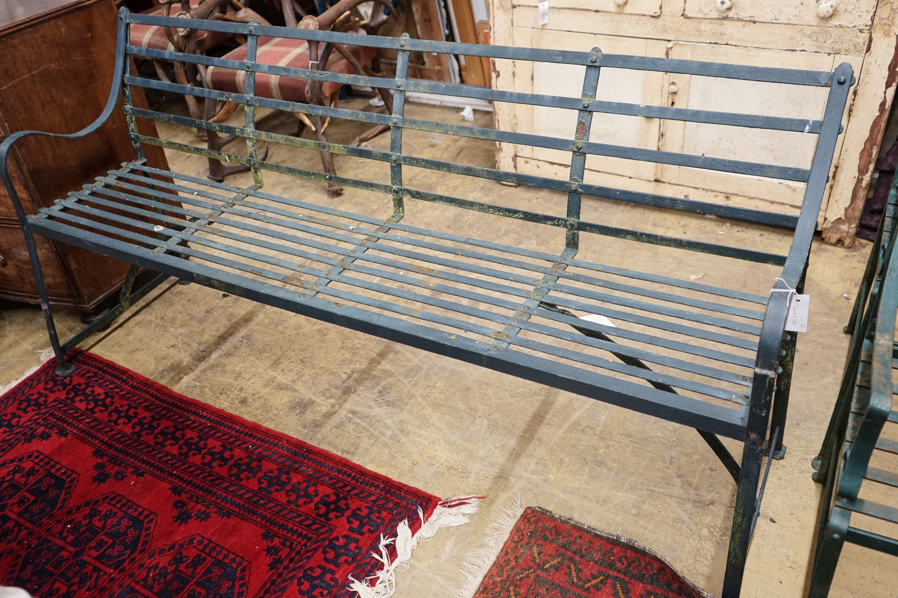 A green painted wrought iron garden bench, length 186cm, depth 46cm, height 92cm together with two Gothic style painted wrought iron garden chairs